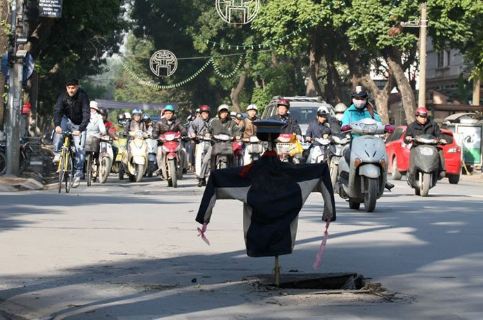 Dùng con "bù nhìn" để cảnh báo hố ga bị bật nắp.